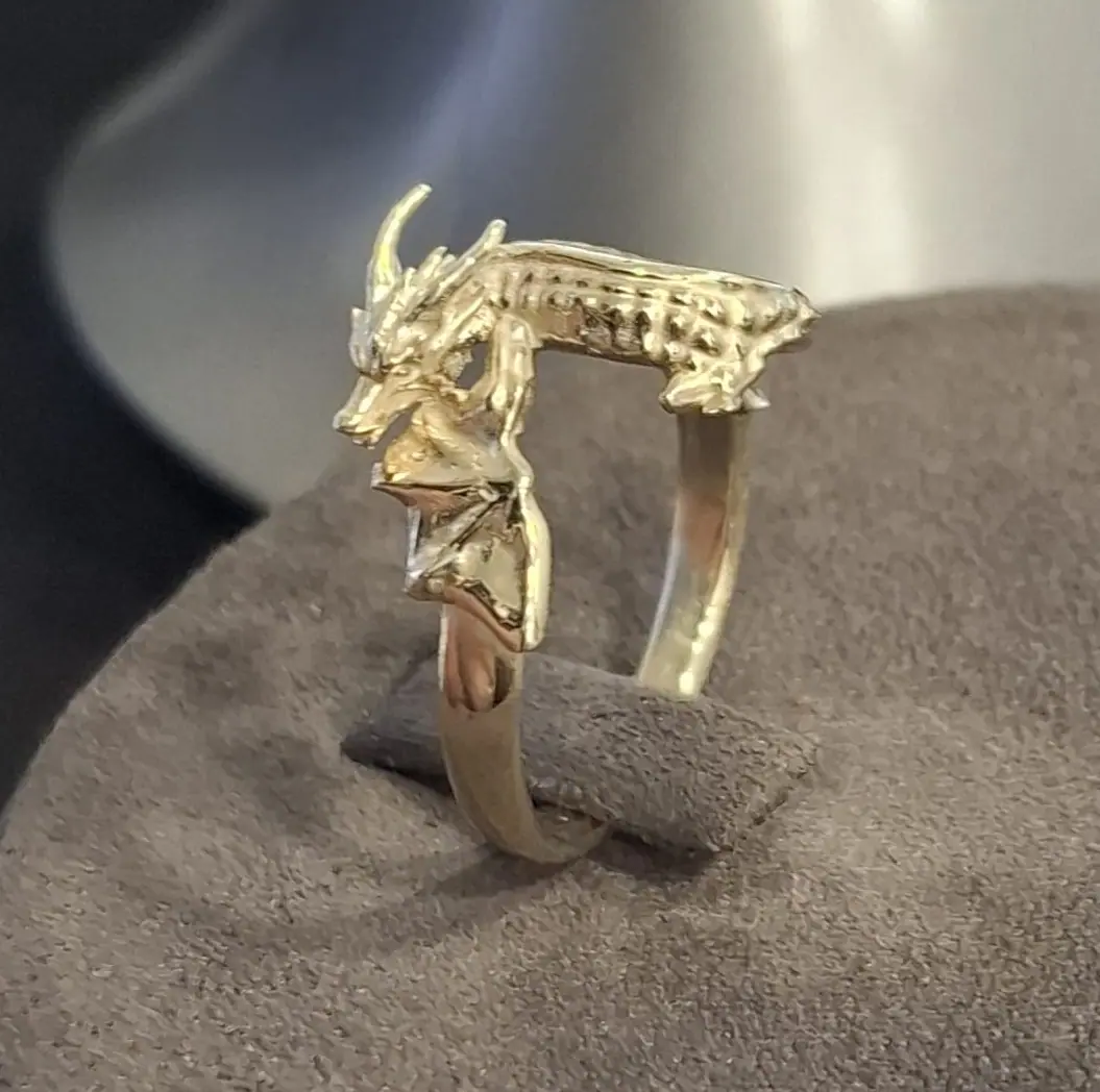 Gold dragon ring on a display stand, front view
