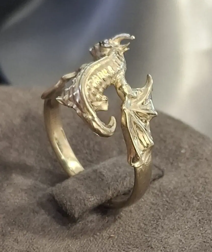 Gold dragon ring on a display stand, wing detail