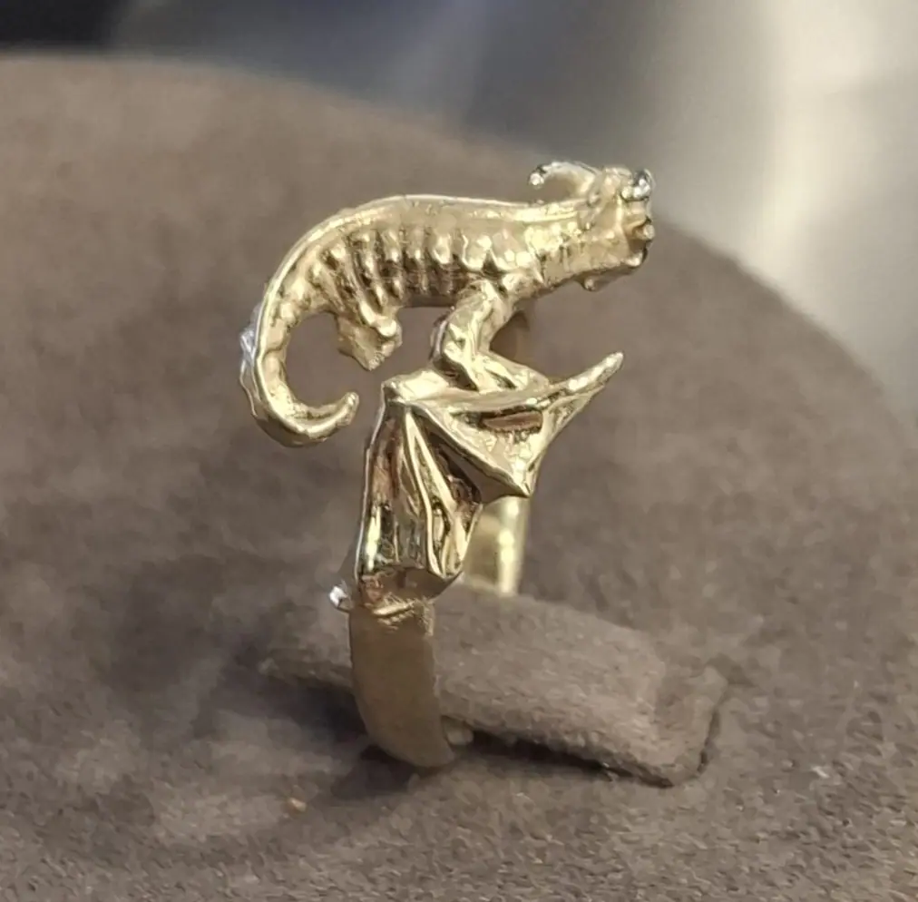 Gold dragon ring on a display stand, tail detail