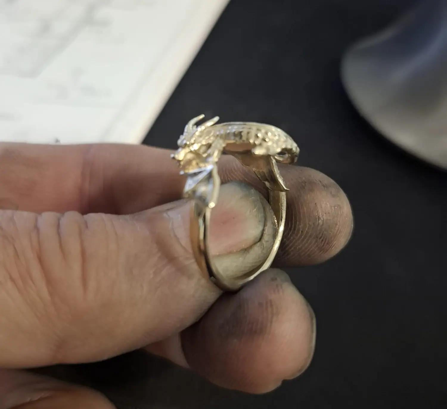 Dragon ring held in a goldsmith's hand