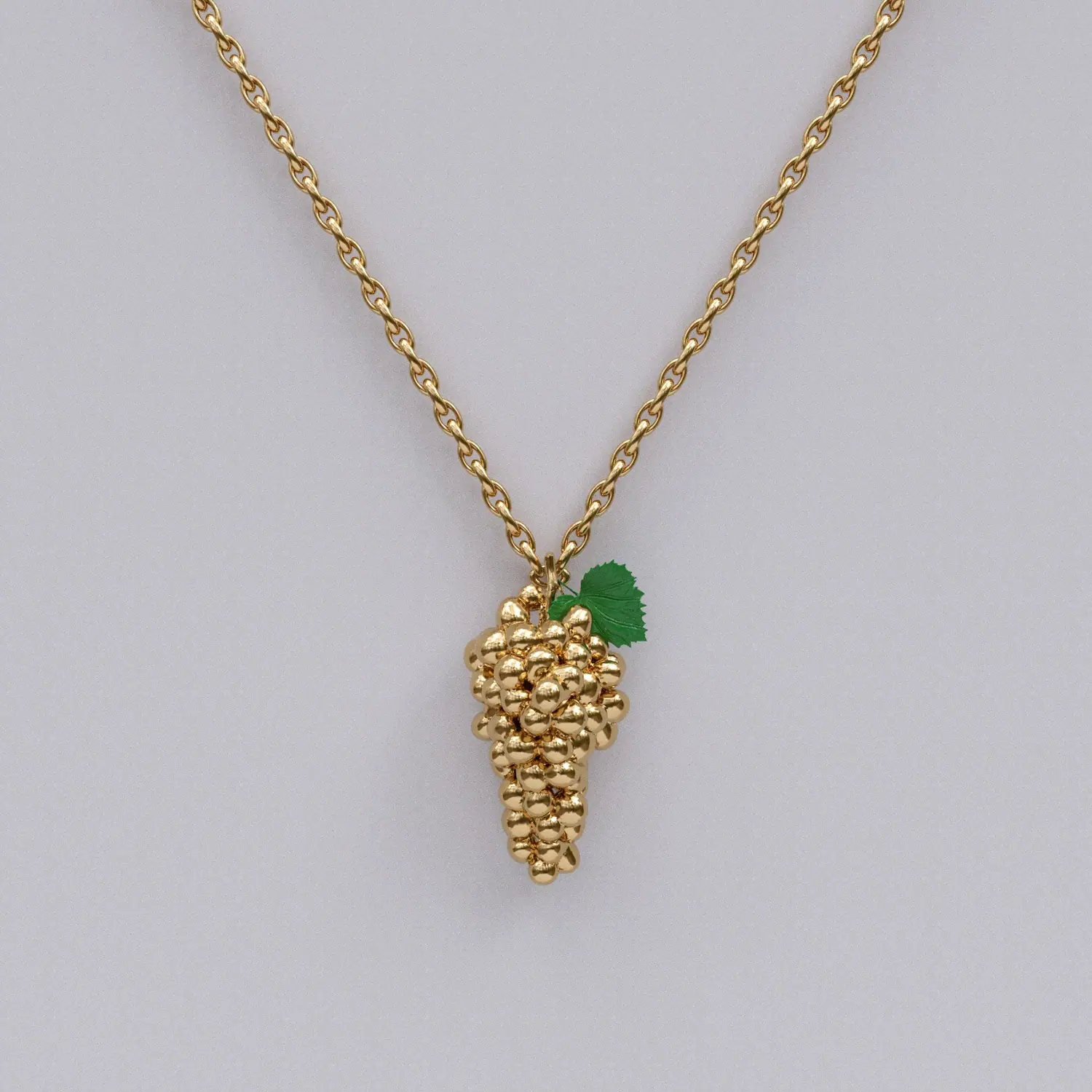 Gold grape bunch pendant with an enamel leaf