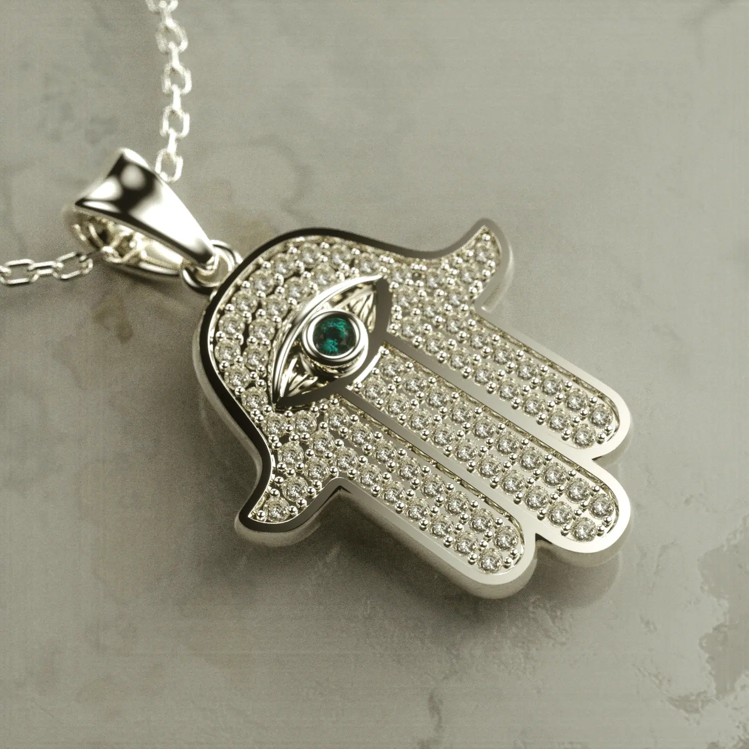 Silver hamsa pendant with a green stone eye