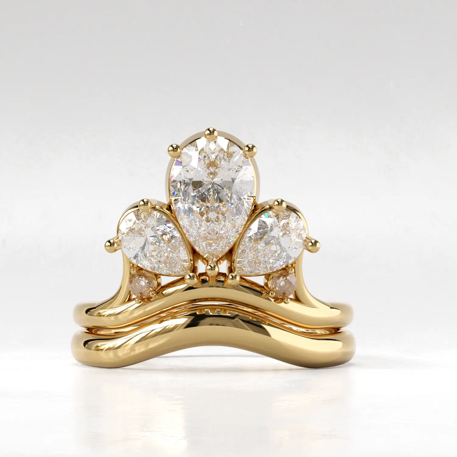 Gold crown ring with three pear-cut stones and a stacking band